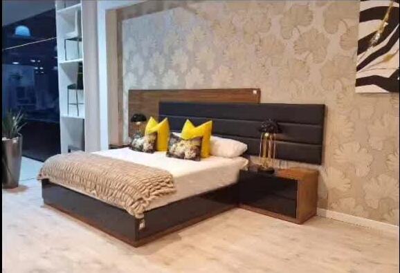 Showroom bed with charcoal upholstered headboard and matching pedestal