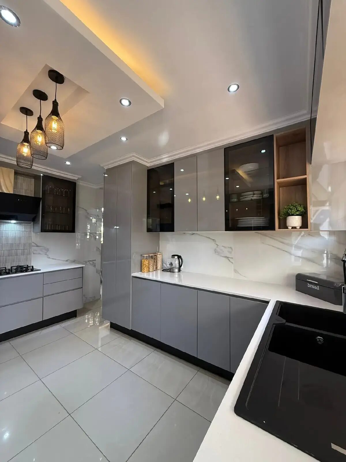 Grey kitchen with cage pendant lights and marble backsplash